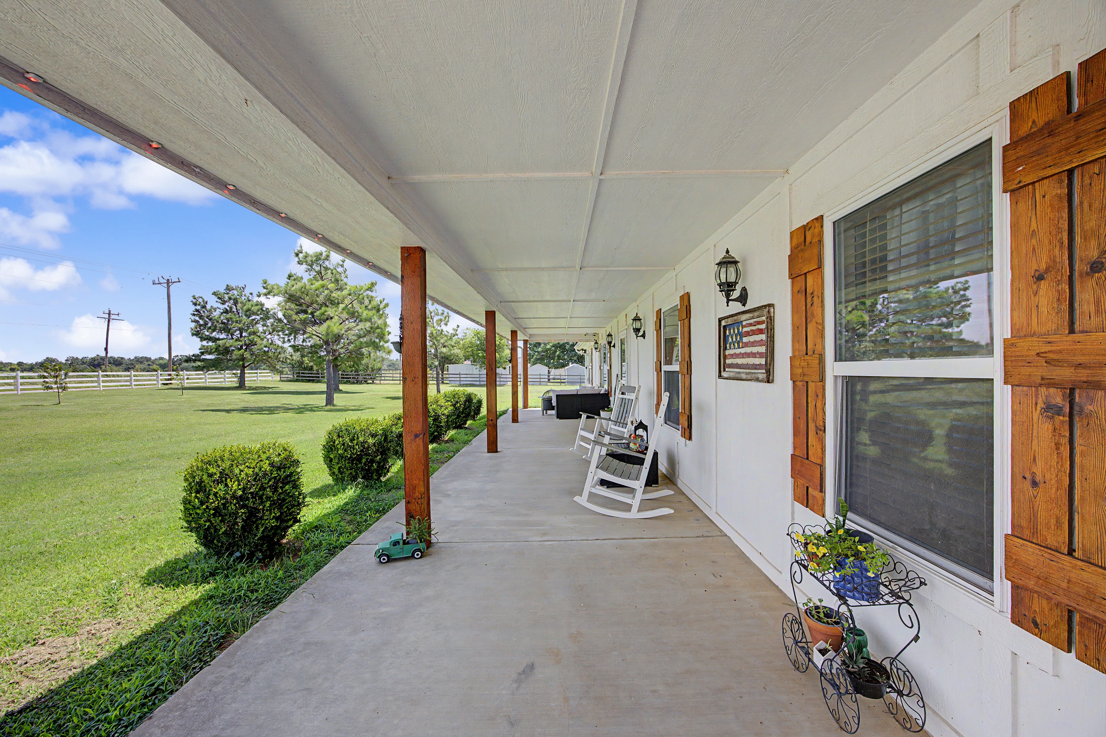Covered porch with rustic wooden doors at 7576 E Maguire Rd