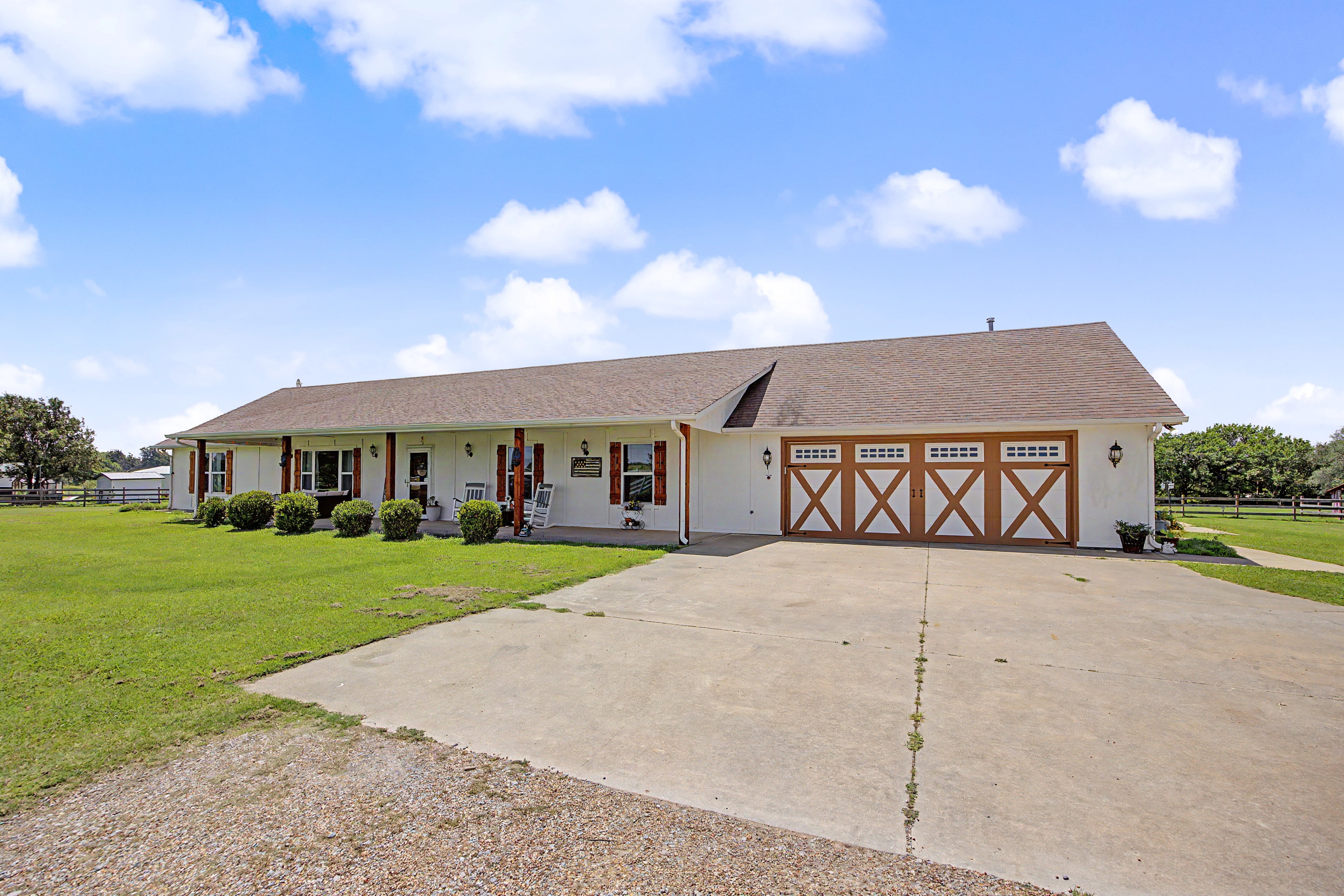 Ranch home exterior with covered porch and barn-style garage at 7576 E Maguire Rd