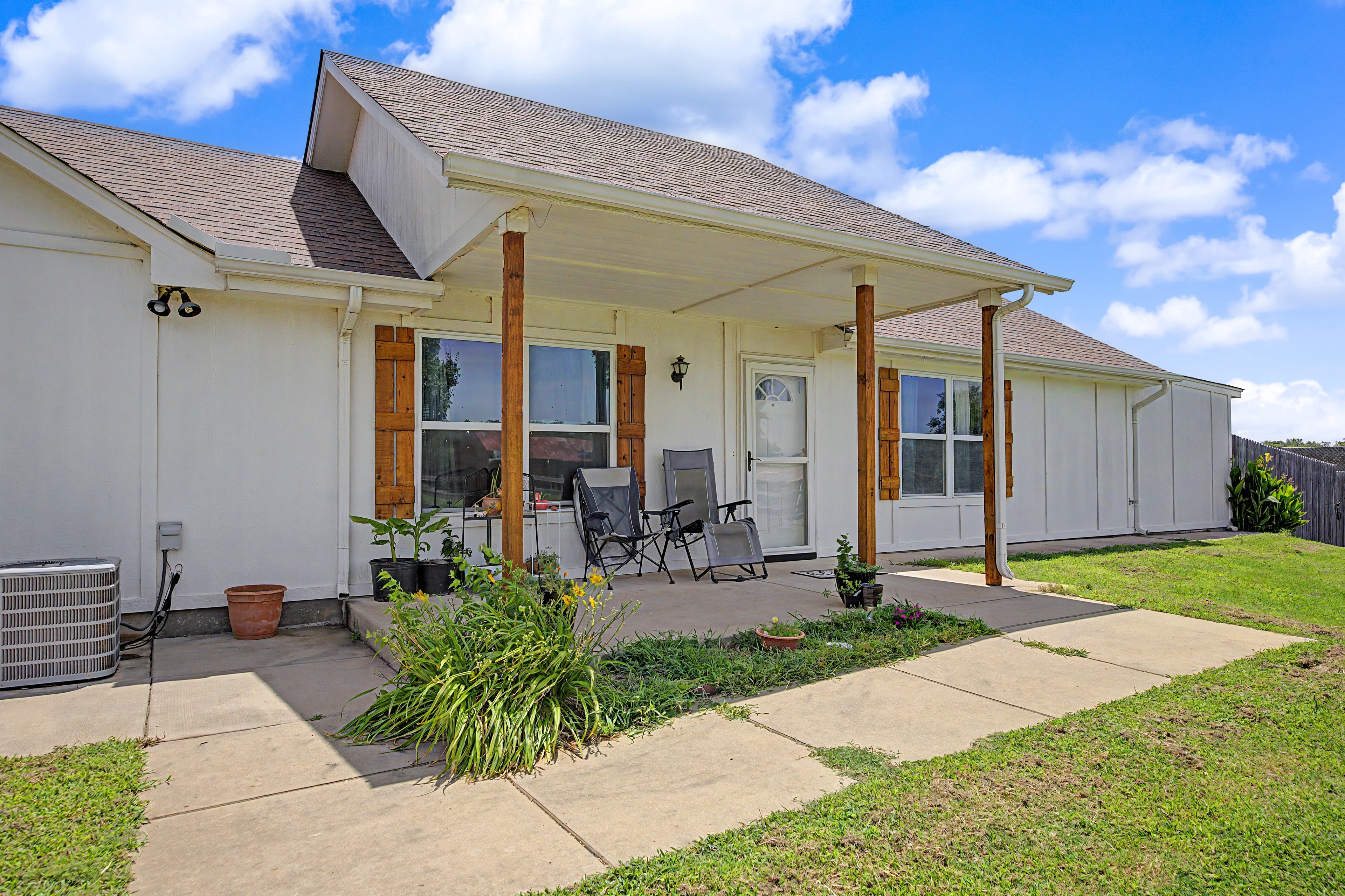 Farmhouse exterior with covered patio and wooden accents at 7576 E Maguire Rd